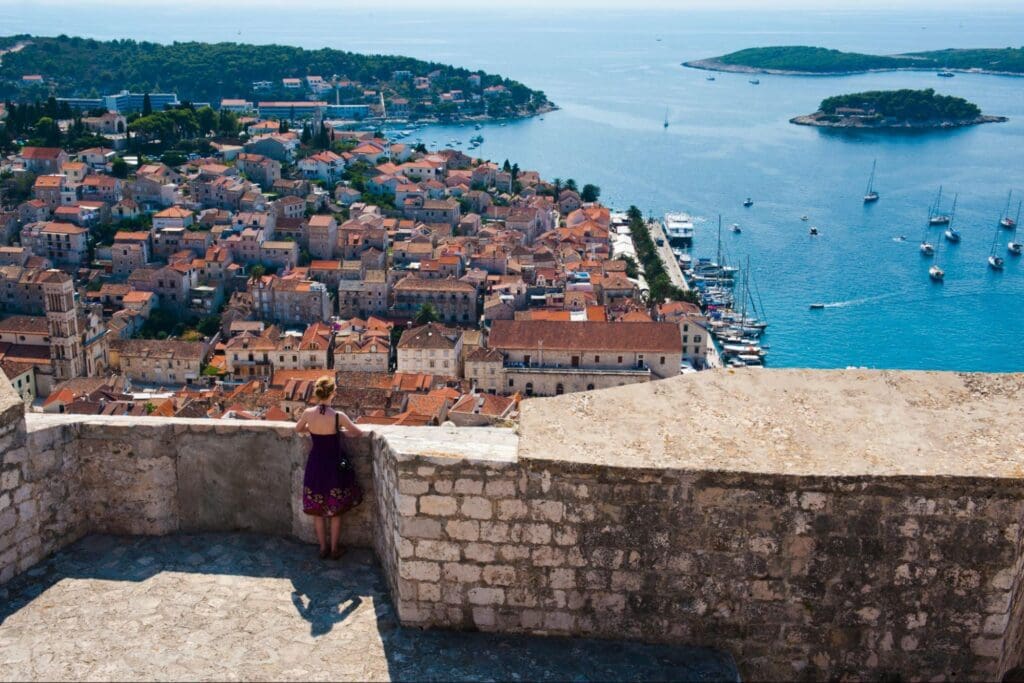 A tourist looks over the Hvar town from the Hvar Spanish Fortress