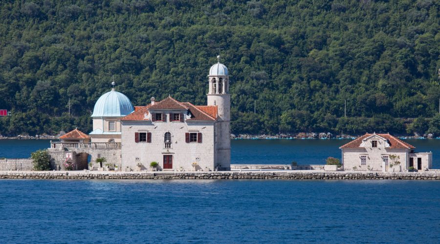 A stone building with a dome and bell tower sits on a small island surrounded by the blue waters of the Adriatic, with a forested hillside in the background, capturing the serene beauty reminiscent of Croatia’s stunning landscapes. A stone building with a dome and bell tower sits on a small island surrounded by the blue waters of the Adriatic, with a forested hillside in the background, capturing the serene beauty reminiscent of Croatia's stunning landscapes.